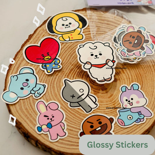A set of glossy BT21 character stickers arranged on a round wood coaster.