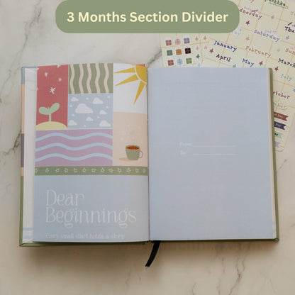 An open planner with a decorative cover page showing a patchwork-style design and the title 'Dear Beginnings,' alongside a green banner reading '3 Months Section Divider.' The pages are blank and light blue-gray, and planner stickers are visible in the background on a marble surface.