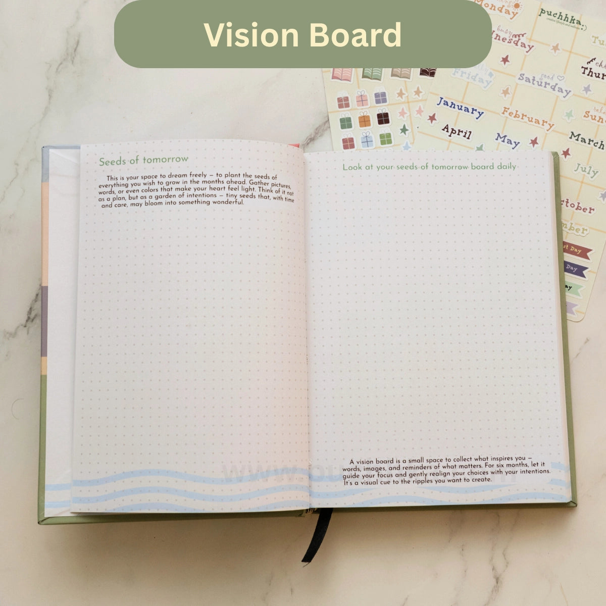 An open Vision Board page in the Daily Planner on a light marble surface, showing dotted pages with inspirational prompts like 'Seeds of tomorrow' and 'Look at your seeds of tomorrow board daily.' A green banner at the top reads 'Vision Board'.