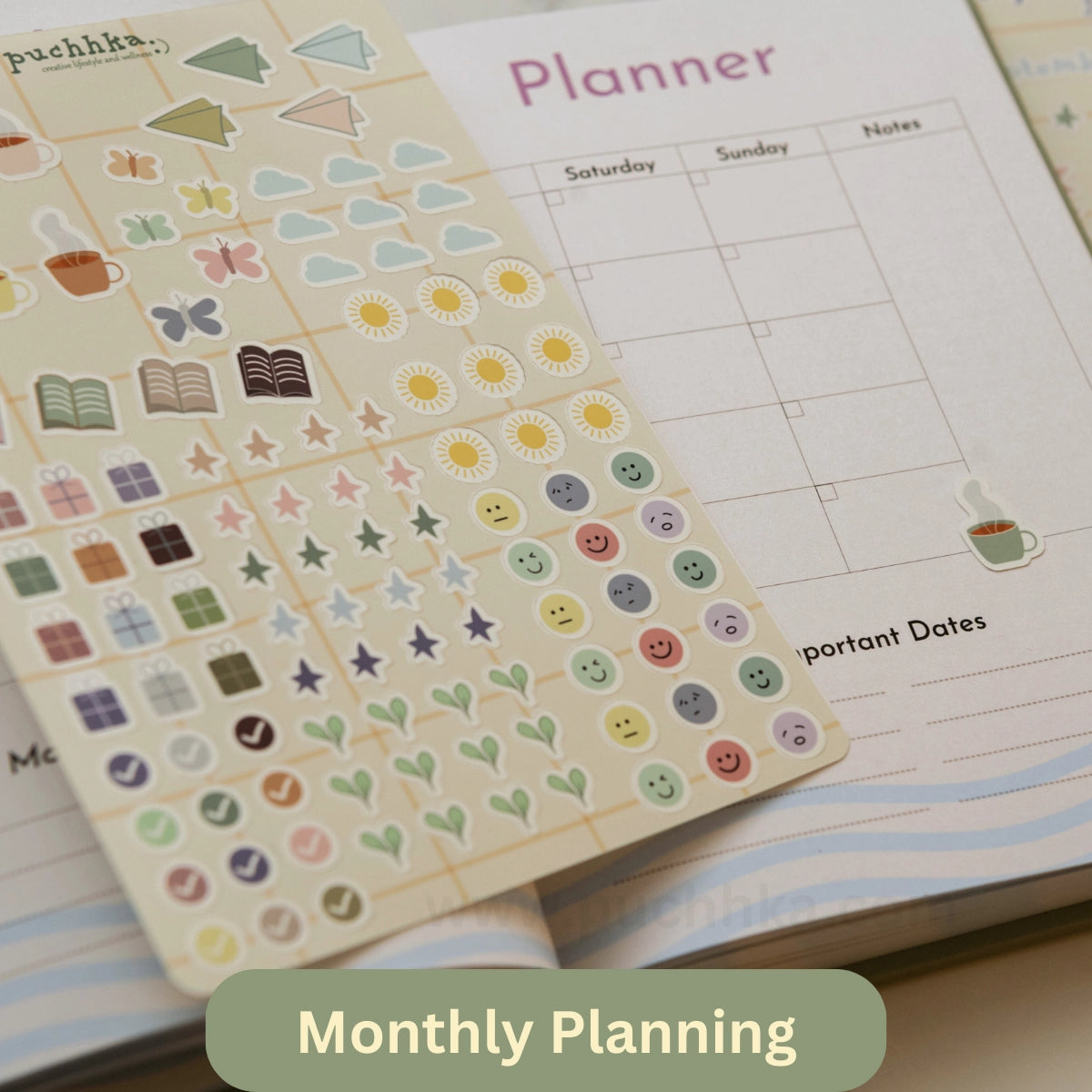 A close-up of a pastel sticker sheet placed over an open planner. The stickers include small icons such as flowers, smiley faces, stars, hearts, books, cups, and checkmarks in soft colors like yellow, pink, green, blue, and brown.