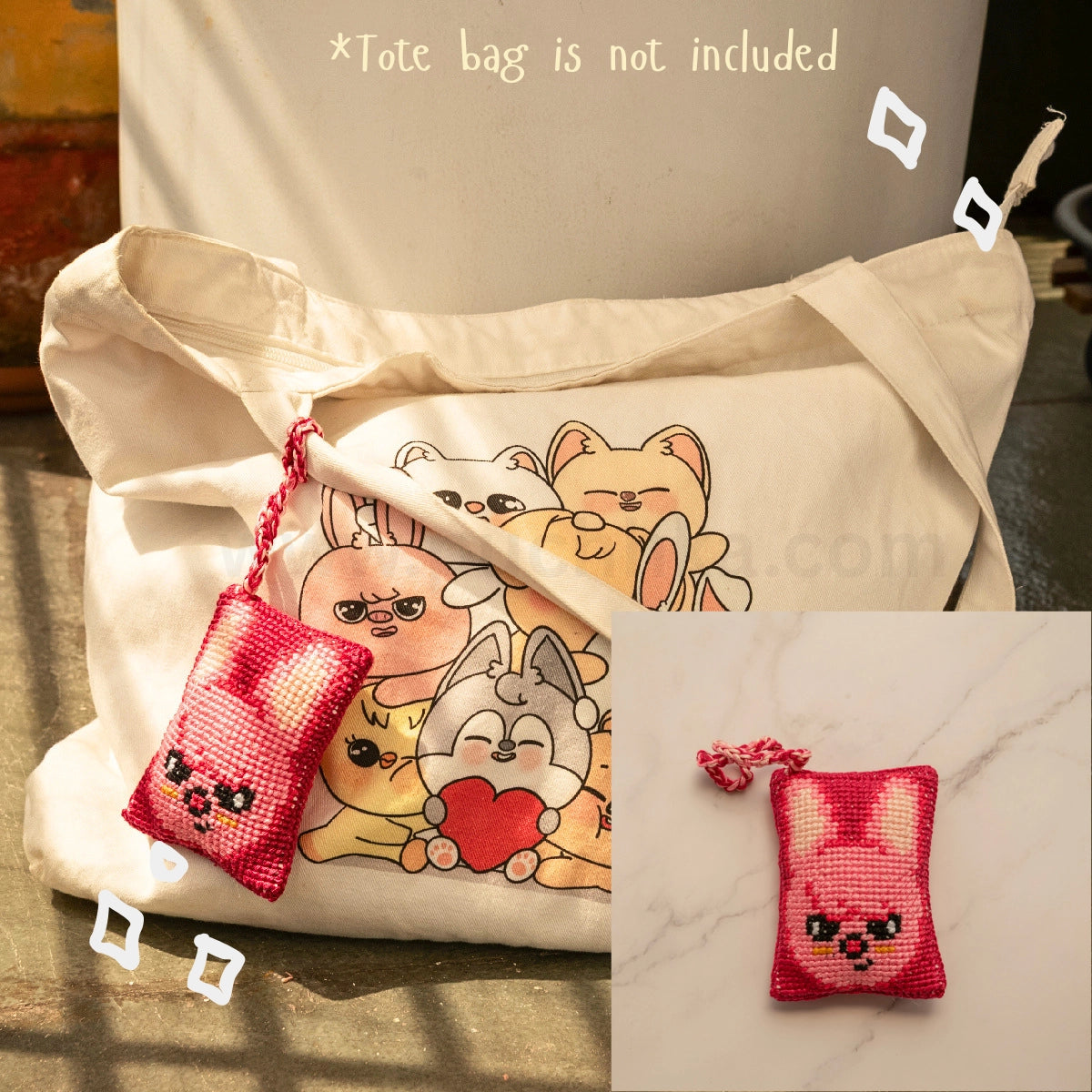 A cream canvas tote bag with a printed skzoo illustration on the front, shown alongside a small pink and white cross-stitch style skzoo bag hanging with a matching strap. The image includes text stating '*Tote bag is not included' and a small inset showing the pouch alone on a marble surface.