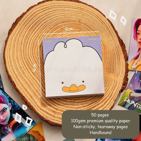 A cute duck-themed notepad by Puchhka  shown on a rustic wood slice background. The notepad features a white duck character on a lavender background with a yellow beak.