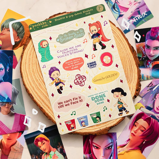 A sheet of colorful character stickers displayed on a round wood slice, surrounded by scattered character art cards. The sticker sheet features illustrated anime-style characters with motivational quotes and music note graphics.