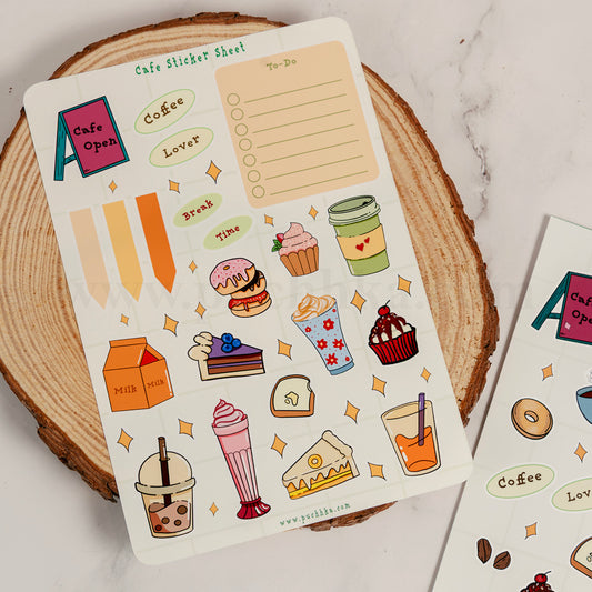 A coffee-themed planner sticker sheet displayed on a wooden coaster, featuring cute illustrations of pastries, drinks, and text stickers like 'Cafe Open', 'Coffee', 'Lover', and a 'To-Do' list.