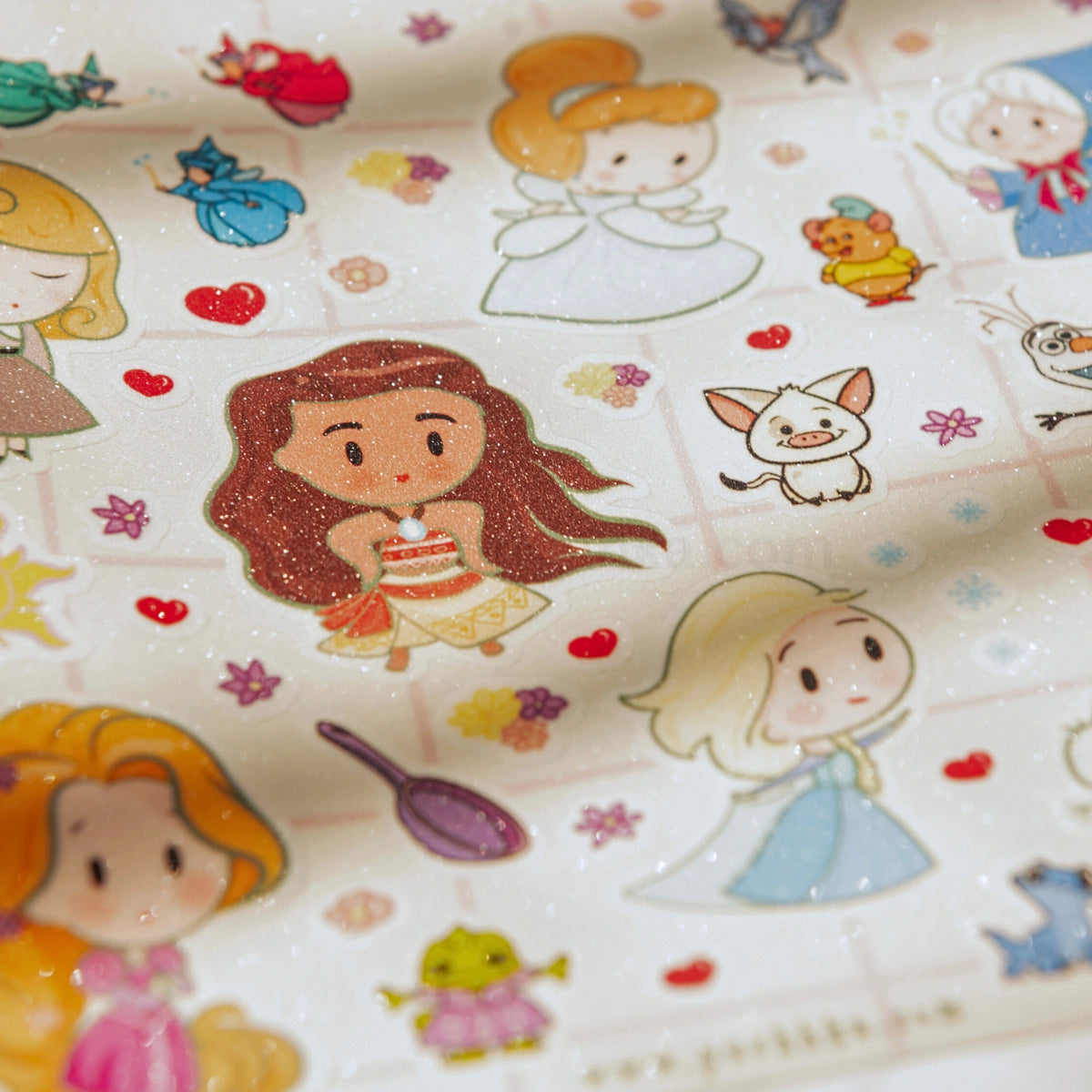 A close-up of a glitter sand finish sticker sheet featuring cute cartoon princess characters and small decorative motifs on a white background.