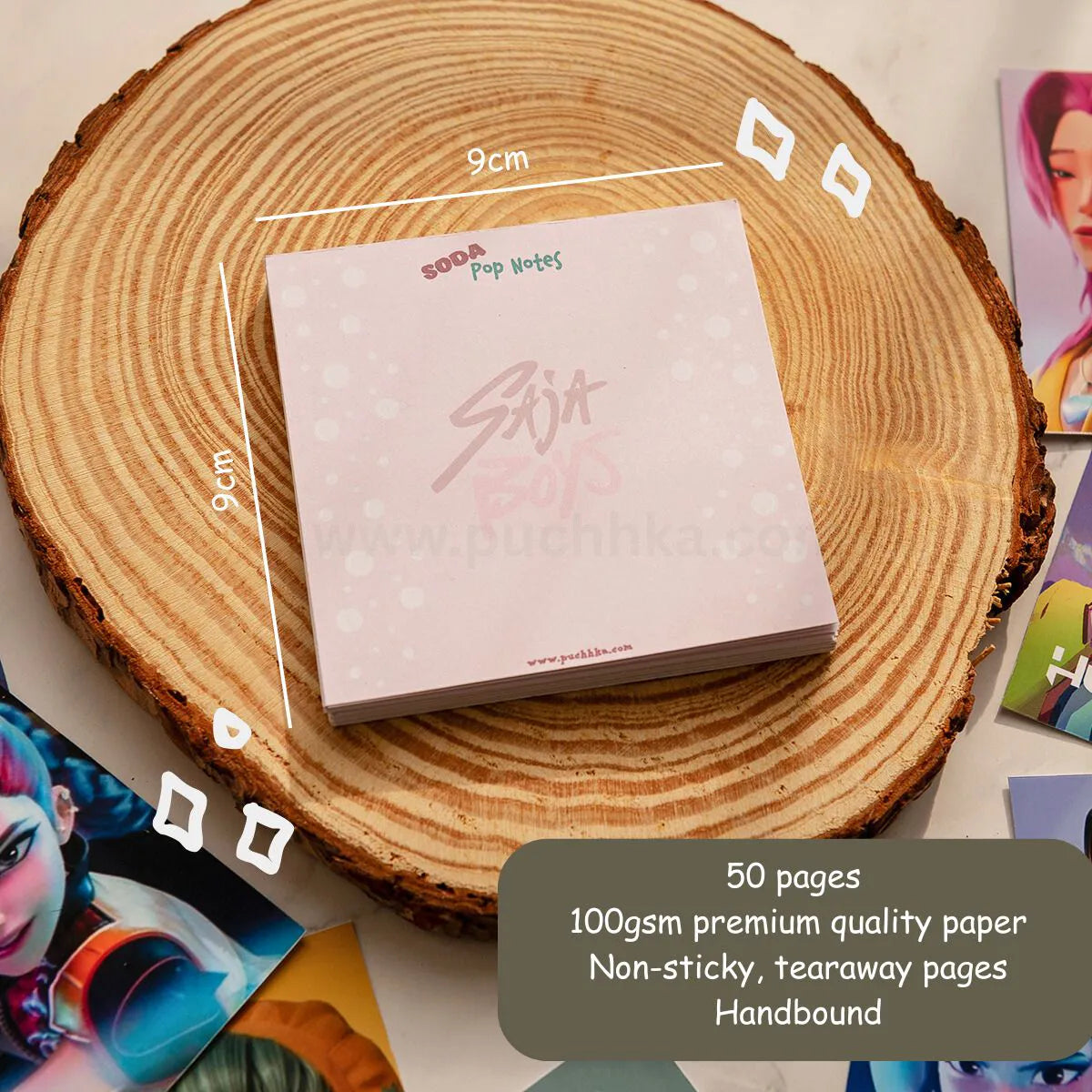 A pink handbound memopad pad labeled 'SODA Pop Notes'  sits on a round wood slice. White measurement lines indicate 9cm by 9cm dimensions, with a dark gray text box noting 50 pages, 100gsm premium quality paper, non-sticky tearaway pages, and handbound construction.