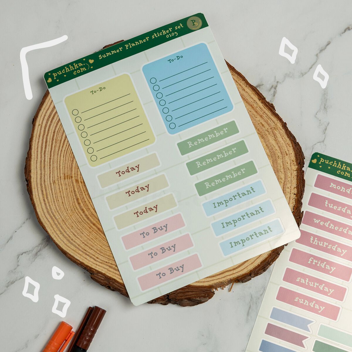 A sheet of pastel planner sticker labels from Puchhka.com is displayed on a round wood slice coaster over a light marble surface.