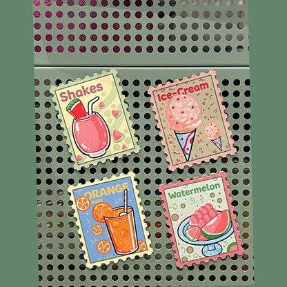 Four illustrated food and drink stamps are arranged on a perforated metal surface. The stamps show a pink drink labeled 'Shakes', pink ice cream cones labeled 'Ice-Cream', an orange drink labeled 'ORANGE', and watermelon slices labeled 'Watermelon'.