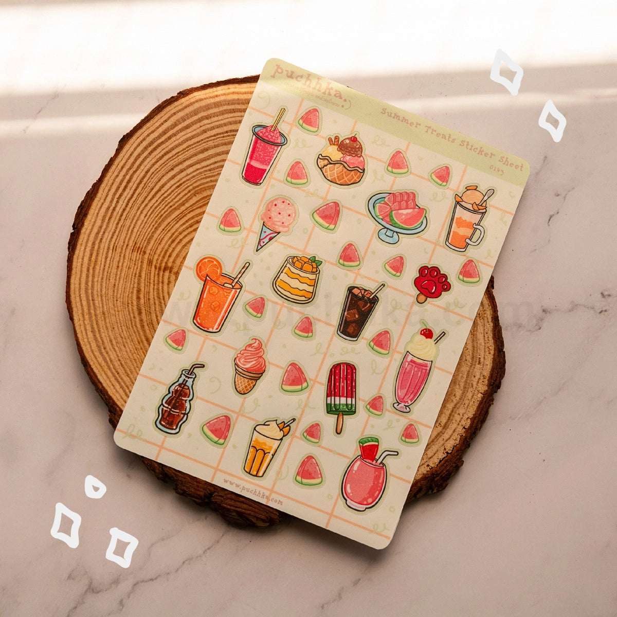 A sheet of summer treat stickers displayed on a rustic wood coaster over a light marble surface. The sticker sheet features colorful illustrations of ice cream, popsicles, watermelon slices, and cocktails.