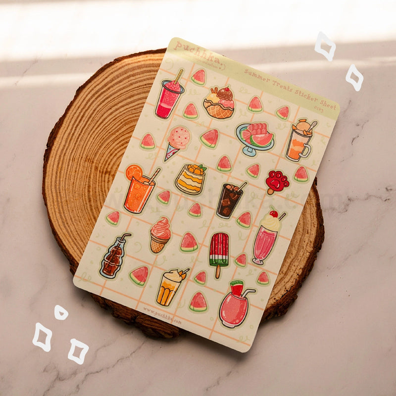 A sheet of summer treat stickers displayed on a rustic wood coaster over a light marble surface. The sticker sheet features colorful illustrations of ice cream, popsicles, watermelon slices, and cocktails.