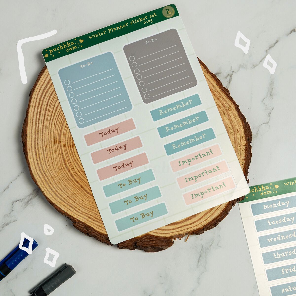 A sheet of pastel planner stickers displayed on a round wood slice coaster over a light marble surface. The stickers include labels such as To-Do, Today, Remember, To Buy, and Important in soft blue, pink, gray, and green tones.