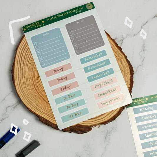 A sheet of pastel planner stickers displayed on a round wood slice coaster over a light marble surface. The stickers include labels such as To-Do, Today, Remember, To Buy, and Important in soft blue, pink, gray, and green tones.